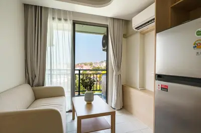 a living room with a couch and a large window at Kamala Beach View 1 BdR Roof Pool 500 mbps WiFi in Kamala Beach
