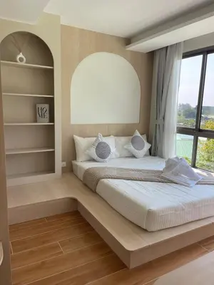 a bedroom with a large bed with a large window at One-bedroom apartments with kitchen in Phuket Town