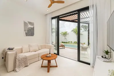 a living room with a couch and a table at Staylar Pool Villas - Bangtao in Ban Pak Lak