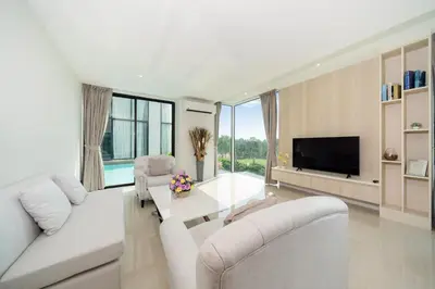 a living room with white furniture and a flat screen tv at Luxury Pool Access 2BR Patong in Patong Beach