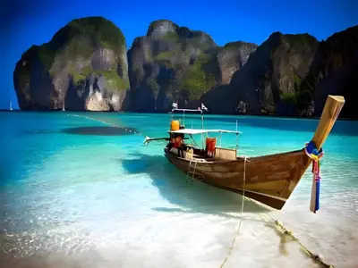 a boat on a beach in the water at XX GO INN Patong Beach Phuket in Patong Beach