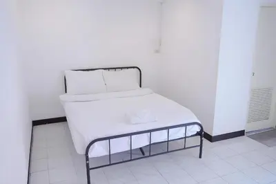 a bed with white sheets and pillows on it at XX GO INN Patong Beach Phuket in Patong Beach