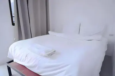 a white bed with white sheets and pillows at XX BAO Patong Beach Phuket - เบาป่าตองบีช in Patong Beach