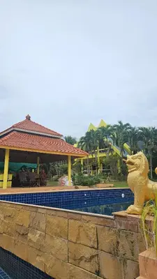 a swimming pool with a lion statue next to a resort at Cozy 1-Bedroom Bungalow with Shared Pool in Rawai in Nai Harn Beach
