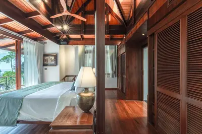 a bedroom with a bed and a lamp on a table at Villa Gecko with sea view pool, walk to Beach & Restaurants in Surin Beach