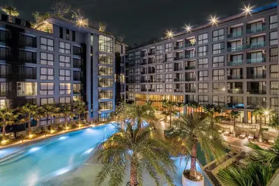 an overhead view of a pool with palm trees in front of buildings at Tropics Kamala 2BR Apartment CTG L602-3, Several Pools, Gym & Rooftop in Kamala Beach