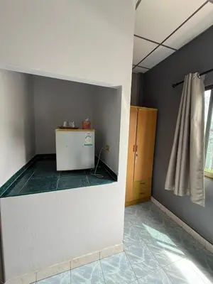 a room with a small refrigerator and a window at Karon Cove at Seabreeze Inn in Karon Beach
