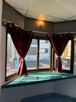 a room with a window with red curtains at Karon Cove at Seabreeze Inn in Karon Beach