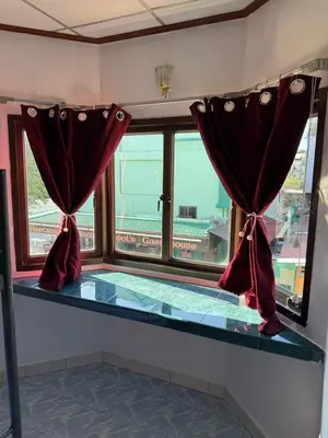 a room with a window with red curtains at Karon Cove at Seabreeze Inn in Karon Beach