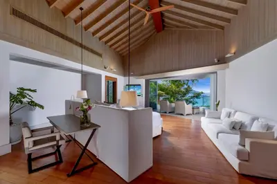 a living room with white furniture and a ceiling fan at Villa Amankara in Phuket Town