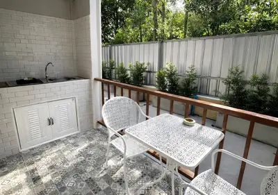 a patio with a table and chairs on a balcony at MBB House in Thalang