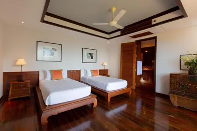 a bedroom with two beds and a ceiling fan at Villa Talaefun - Luxury Oceanfront Fully Serviced in Kamala Beach