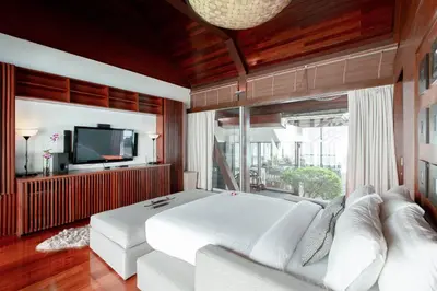 a bedroom with a white bed and a tv at Villa Laemsingh 2 Oceanfront Fully Serviced in Surin Beach