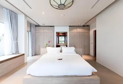a bedroom with a large white bed and windows at Villa Laemsingh 2 Oceanfront Fully Serviced in Surin Beach