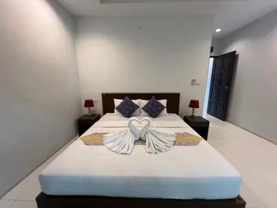 a bedroom with a bed with a bow on it at Nern khao Guesthouse in Kamala Beach