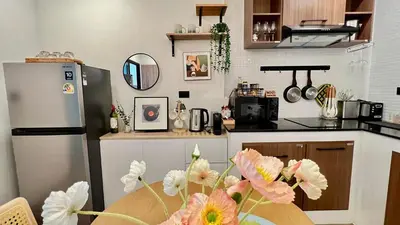 a kitchen with a refrigerator and a table with flowers at Charming home patong in Patong Beach