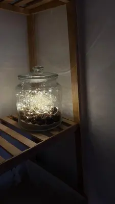 a jar with lights in it sitting on a shelf at Kates cozy place in Mai Khao Beach