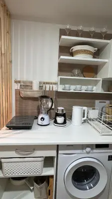 a white kitchen with a washing machine in it at Kates cozy place in Mai Khao Beach