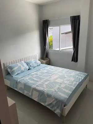 a bedroom with a bed with blue sheets and a window at Family House in Bang Tao in Ban Thalat Choeng Thale