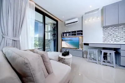 a living room with a couch and a fireplace at Tropics Hill View Apartment CTG L706 at Kamala Residence, Top Amenities, Close to the Beach and Fantasea in Kamala Beach