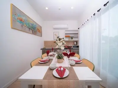 a dining room with a white table with flowers on it at 4Luxury Pool Villa 4 Bedrooms Private Pool Kitchen in Ban Bang La