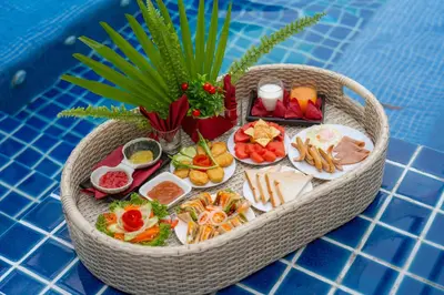 a basket of food on a table next to a pool at 3Elegant 4BR Villa with Pool in Ban Bang La