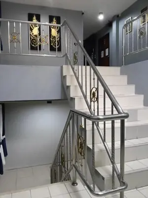 a staircase in a house with white stairs and silver railings at Sparta beachfront patong in Patong Beach