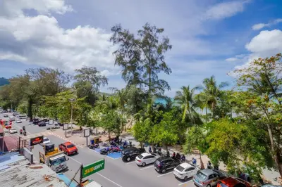 a busy city street with cars parked on the road at Sparta beachfront patong in Patong Beach