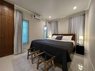 a bedroom with a large bed and two chairs at Home Tambon Bang tao 2BR Near Beach in Surin Beach