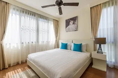 a bedroom with a large bed with blue pillows at Laguna Park Townhouse by Villacarte in Laguna Phuket