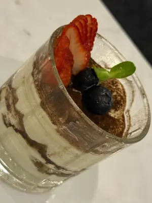 a dessert in a glass dish with a fruit on top at The little Mermaid in Patong Beach