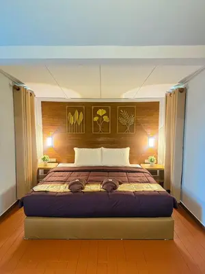 a bedroom with a large bed with two lamps at Green Haven Villas in Krabi town