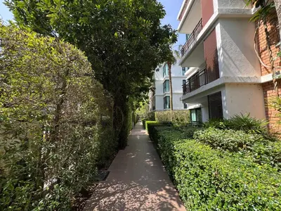 a sidewalk next to a building with a tree at Apartment Title III Rawai Phuket in Rawai Beach