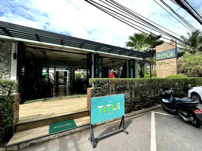 a sign in front of a building with a motorcycle parked in front at Apartment Title III Rawai Phuket in Rawai Beach