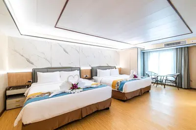 a hotel room with two beds with flowers on them at Phuket Patong Buri Resort in Patong Beach