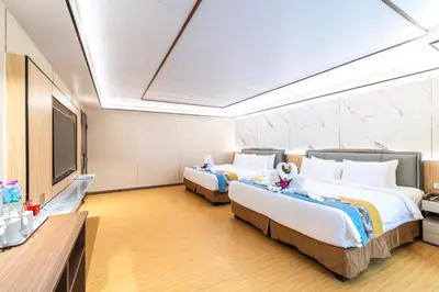 a hotel room with two beds and a flat screen tv at Phuket Patong Buri Resort in Patong Beach