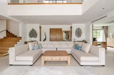 a living room with a white couch and a coffee table at WEG Laguna Residence in Thalang