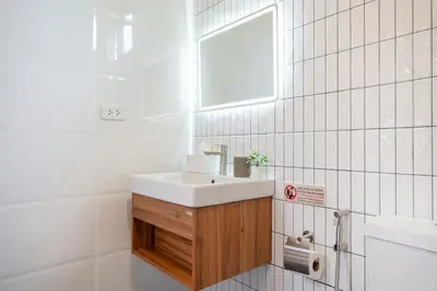 a white bathroom with a sink and a mirror at 6BR Patong pool villa in Patong Beach