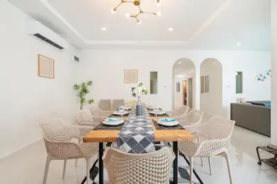 a dining room with a long table and chairs at 6BR Patong pool villa in Patong Beach