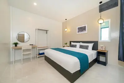 a bedroom with a large bed and a desk at 6BR Patong pool villa in Patong Beach