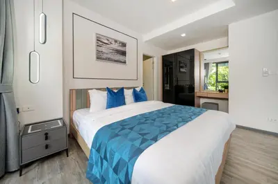 a bedroom with a large bed with blue pillows at Patong luxurious Vacation one bedroom Apt The deck in Patong Beach