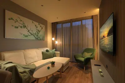 a living room with a white couch and a green chair at 1bdr New Apartment near Layan Beach in Ko Kala