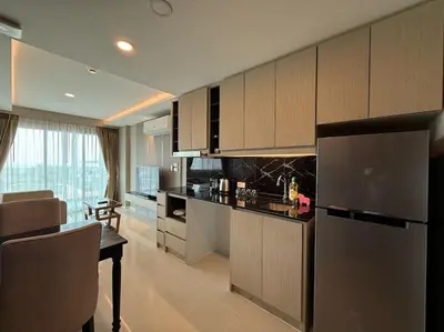 a kitchen with a refrigerator and a table in a room at Surin Mida Grande residence with jacuzzi and sea view - Bang Tao & Surin beach in Surin Beach
