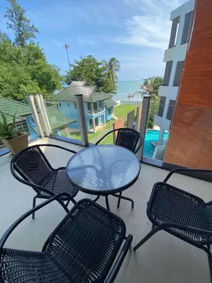 a patio with a table and chairs and a pool at Beachfront in Surin Beach
