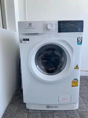 a white washing machine sitting in a room at Beachfront in Surin Beach