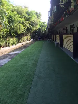 a green lawn in front of a building at Nan Inn Bungalow in Karon Beach