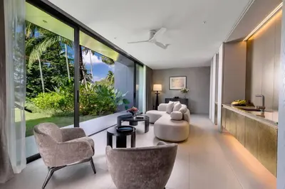 a living room with a couch and chairs and windows at Villa Zai in Kata Beach