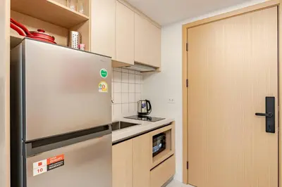 a kitchen with a stainless steel refrigerator and cabinets at Fantasea Kamala Walk to Beach Pool & Gym Modern 1BR in Kamala Beach
