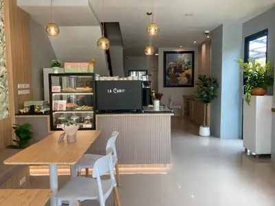 a restaurant with a table and chairs and a counter at The Village Poshtel in Ban Khlong Haeng
