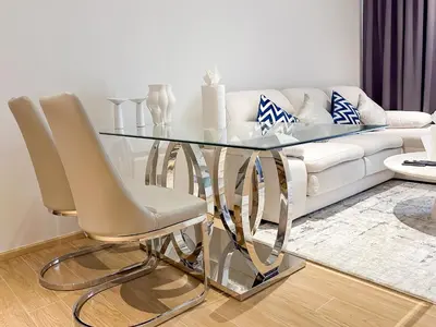 a glass dining room table with two chairs and a couch at Laguna BeachSide Apartment in Bang Tao Beach